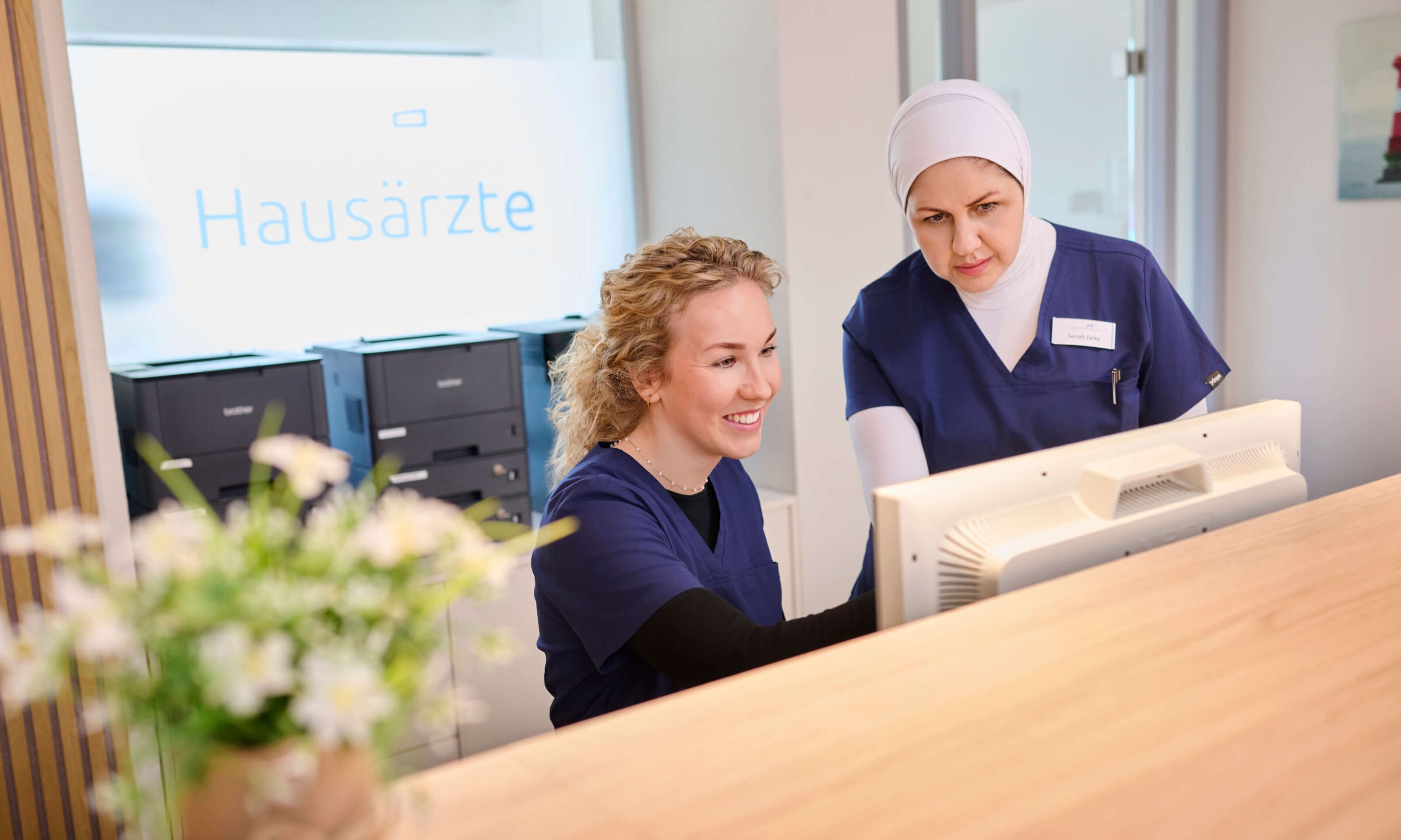 zwei Mitarbeiterinnen stimmen sich in der Praxis ab